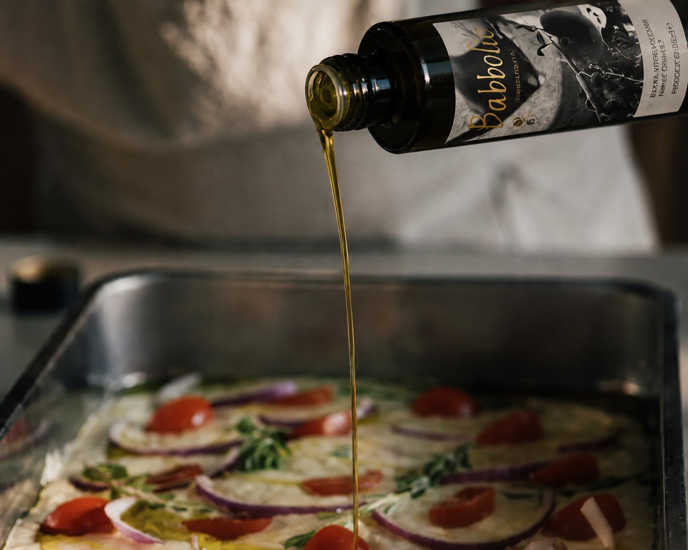 Babbolio extra virgin olive oil being poured over vegetables in a professional kitchen